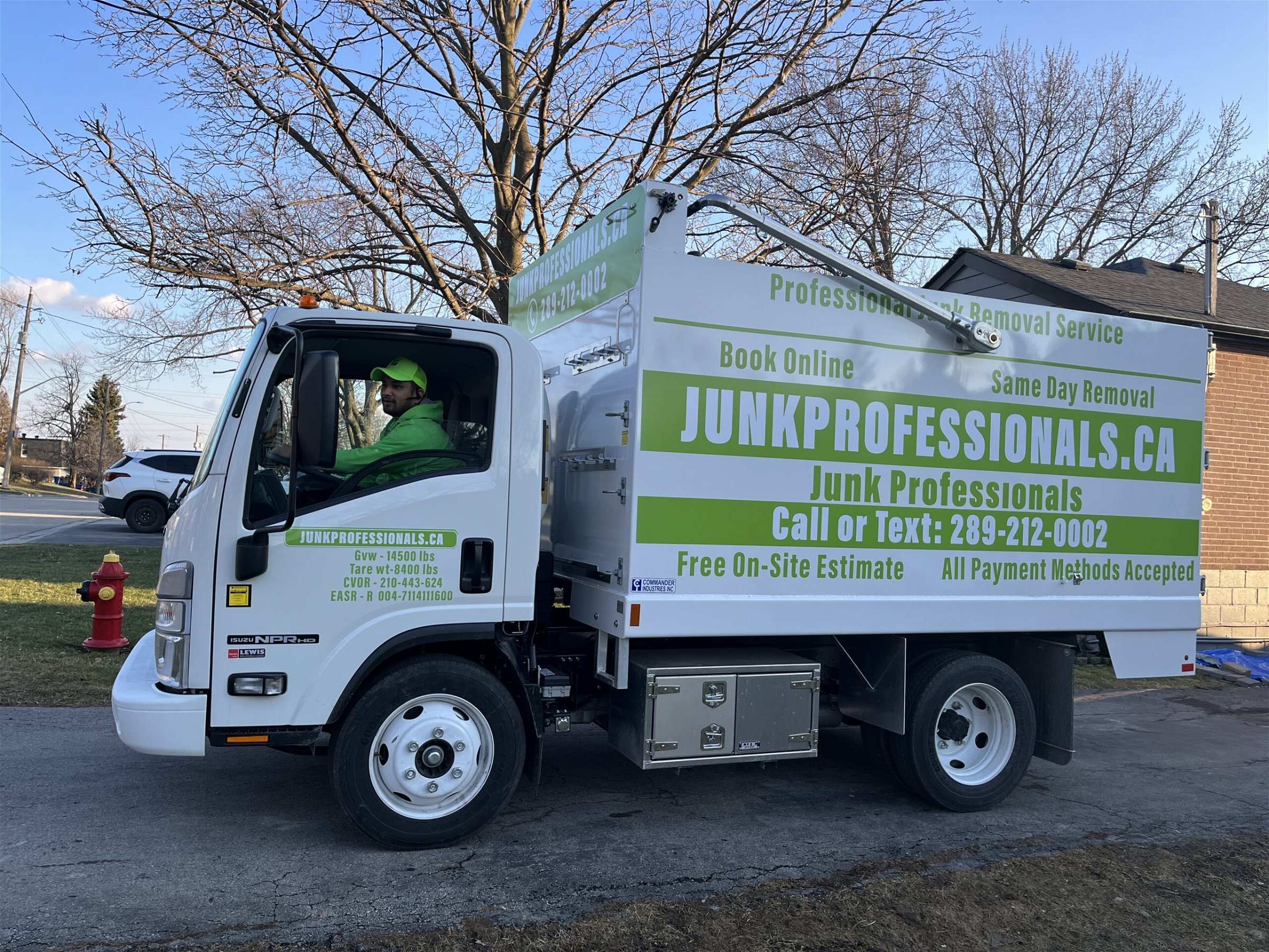 Junk professionals truck with a employee sitting in it is on location to provide warehouse cleanout service