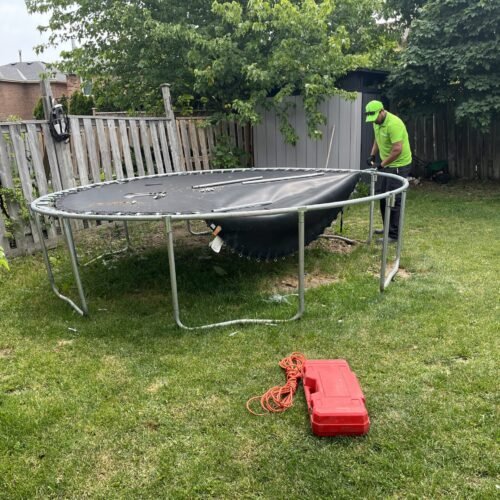 Junk Professionals' employee demolishing trampoline and removing it